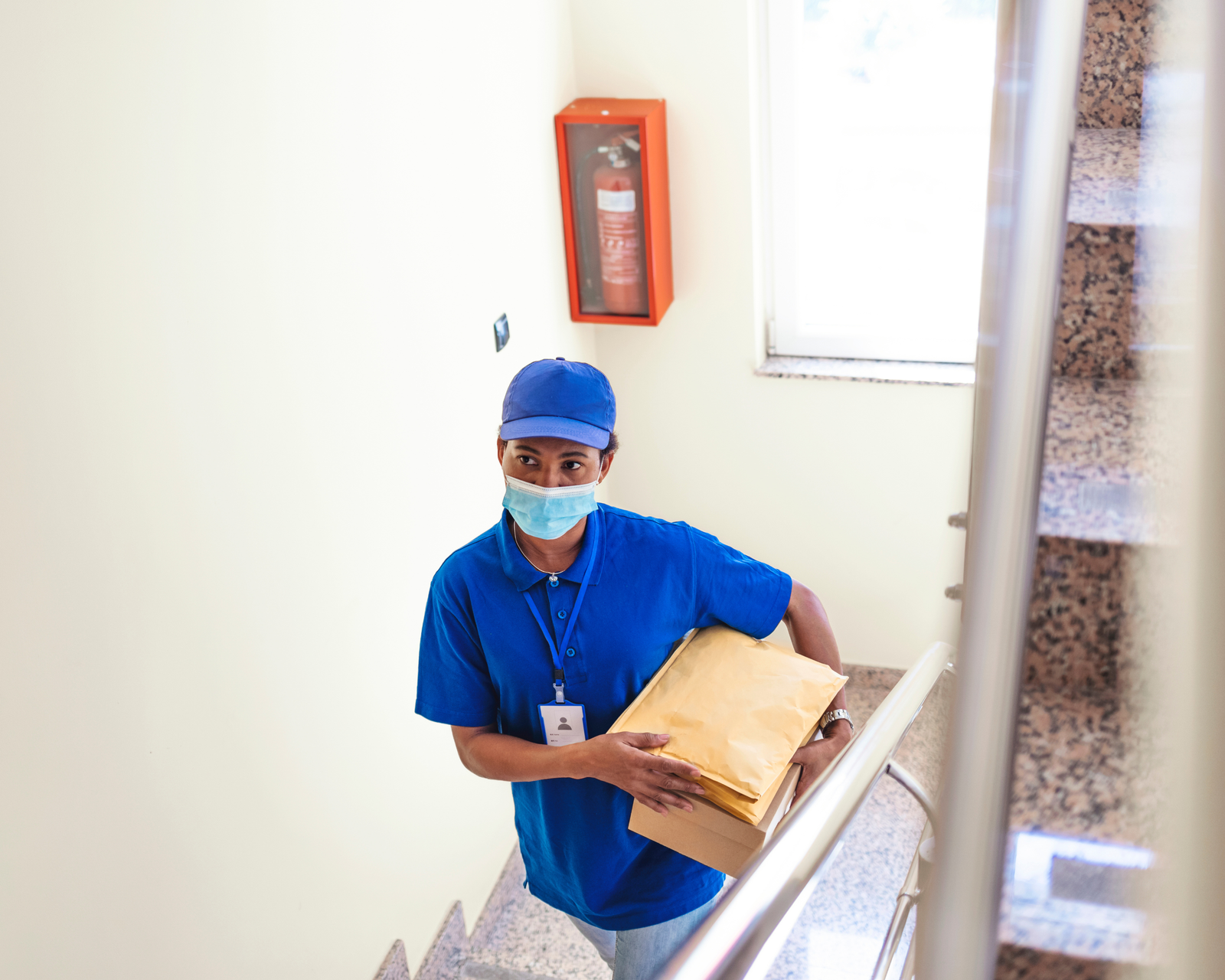 Courier carrying medical and business packages indoors